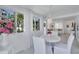 Bright dining area features white furnishings, views of lush greenery, and seamless flow to the living area at 643 Calle Del Otono, Sarasota, FL 34242