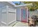 Exterior view showing an outdoor shower, lush landscaping, a pink entry door, and a grill at 643 Calle Del Otono, Sarasota, FL 34242