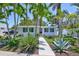 Inviting home with tropical foliage, showcasing a well-maintained lawn and quaint pink door at 643 Calle Del Otono, Sarasota, FL 34242