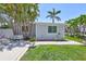Charming single-story home with tropical landscaping, including palm trees and a well-manicured lawn at 643 Calle Del Otono, Sarasota, FL 34242