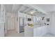 Contemporary white kitchen with stainless steel appliances, island, and herringbone floors at 643 Calle Del Otono, Sarasota, FL 34242