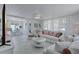 Open-concept living room with white furniture, sheer curtains, and a dining area in view at 643 Calle Del Otono, Sarasota, FL 34242