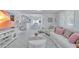 Bright living room with white furniture, TV, and open view to the kitchen and dining area at 643 Calle Del Otono, Sarasota, FL 34242