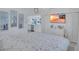 Bright main bedroom with beach sunset on TV, closet space, and partial view to the kitchen at 643 Calle Del Otono, Sarasota, FL 34242