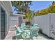 Outdoor patio features a glass table, four chairs, a grill, lush landscaping, and a pink entry door at 643 Calle Del Otono, Sarasota, FL 34242