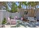 Cozy outdoor patio with white furniture, pink cushions, and palm trees at 643 Calle Del Otono, Sarasota, FL 34242