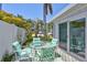 Outdoor patio features a glass table, four chairs, a palm tree, and sliding glass doors to the home at 643 Calle Del Otono, Sarasota, FL 34242
