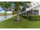 Manicured backyard of home featuring a serene lake view and mature trees at 6572 Fairway Gardens Dr # 6572, Bradenton, FL 34203