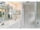 A bathroom featuring wallpaper, a double sink vanity, a mirror, and a shower at 6572 Fairway Gardens Dr # 6572, Bradenton, FL 34203