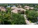 Aerial view of tile roof home showcasing lush landscaping with lake view at 6808 Belmont Ct, Lakewood Ranch, FL 34202