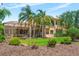 Exterior shot of the house with a beautiful screened-in lanai and pool overlooking a landscaped yard with palm trees at 6808 Belmont Ct, Lakewood Ranch, FL 34202