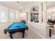 Bright game room with a pool table and wet bar, connects to living areas with classic archways at 6808 Belmont Ct, Lakewood Ranch, FL 34202