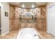 Beautiful bathroom featuring a soaking tub and dual shower heads surrounded by decorative tile at 6808 Belmont Ct, Lakewood Ranch, FL 34202