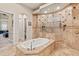 Beautiful bathroom featuring a soaking tub and dual shower heads surrounded by decorative tile at 6808 Belmont Ct, Lakewood Ranch, FL 34202