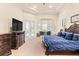 Serene main bedroom with a tray ceiling, French doors to lanai, and decorative details at 6808 Belmont Ct, Lakewood Ranch, FL 34202
