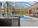 Outdoor poolside kitchen with sink and built-in refrigerator at 6808 Belmont Ct, Lakewood Ranch, FL 34202