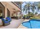 Screened-in pool patio has outdoor kitchen and seating with lush landscaping views at 6808 Belmont Ct, Lakewood Ranch, FL 34202