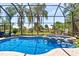 Sparkling screened-in pool with an attached jacuzzi, a water feature, and lush landscaping, offering a luxurious outdoor retreat at 6808 Belmont Ct, Lakewood Ranch, FL 34202