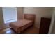 Plain bedroom with a window featuring blinds and wood-look flooring at 7004 Mauna Loa Blvd, Sarasota, FL 34241