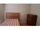 Modest bedroom featuring a bed, dresser, and wood-look flooring at 7004 Mauna Loa Blvd, Sarasota, FL 34241