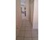 Hallway featuring neutral-toned tile floors and a view towards an open kitchen and dining area at 7004 Mauna Loa Blvd, Sarasota, FL 34241