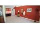 Bright living room featuring tile flooring, a red accent wall, and stylish decorative furnishings at 7004 Mauna Loa Blvd, Sarasota, FL 34241