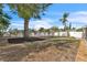 View of the backyard with white fencing, mature trees and manicured black mulch at 7205 Pointe West Blvd, Bradenton, FL 34209