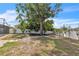 Mature tree centered in backyard with walkway and fire pit, pool in the background at 7205 Pointe West Blvd, Bradenton, FL 34209