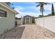 The backyard features a shed and a gravel-covered area, enclosed by a white fence and lush landscaping at 7205 Pointe West Blvd, Bradenton, FL 34209