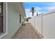 Side yard featuring white privacy fence and gravel-covered area, providing a secure and low-maintenance outdoor space at 7205 Pointe West Blvd, Bradenton, FL 34209