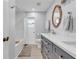 Bathroom featuring double sink vanity, framed oval mirror, shower/tub with white tiled walls at 7205 Pointe West Blvd, Bradenton, FL 34209