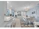 Bright dining area featuring a modern chandelier, white table with seating and connected kitchen area at 7205 Pointe West Blvd, Bradenton, FL 34209