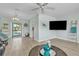 Bright living room featuring modern flooring, a ceiling fan, and sliding glass doors to the pool at 7205 Pointe West Blvd, Bradenton, FL 34209