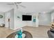 Bright living room featuring modern flooring, a ceiling fan and a large wall-mounted television at 7205 Pointe West Blvd, Bradenton, FL 34209