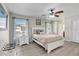 Brightly lit main bedroom with ceiling fan, beach decor, and wood-look floors at 7205 Pointe West Blvd, Bradenton, FL 34209