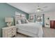 Bright main bedroom features white furnishings, coastal decor, and an ensuite bathroom at 7205 Pointe West Blvd, Bradenton, FL 34209
