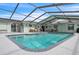 A wide view of the screened-in pool and hot tub with outdoor seating under a blue sky at 7205 Pointe West Blvd, Bradenton, FL 34209