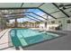 A view of the pool and spa with screened enclosure, outdoor seating and view to the house at 7205 Pointe West Blvd, Bradenton, FL 34209