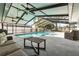 Relaxing screened-in pool and spa area with ceiling fans, seating, and dark stained wooden table at 7205 Pointe West Blvd, Bradenton, FL 34209