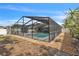 View of the screened pool and spa area with tropical foliage and white fencing around property at 7205 Pointe West Blvd, Bradenton, FL 34209