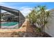 A walkway next to the screened in pool and spa with a white fence and tropical foliage at 7205 Pointe West Blvd, Bradenton, FL 34209