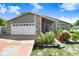 Charming single-Gathering home featuring stone accents, a two-car garage, and mature landscaping at 7321 Caladesia Dr, Sarasota, FL 34243
