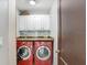 Convenient laundry room featuring dual red machines and ample cabinet space at 7321 Caladesia Dr, Sarasota, FL 34243