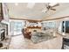 Spacious living room with stone fireplace, wood beams, and tile floors with views into the kitchen at 7321 Caladesia Dr, Sarasota, FL 34243