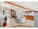 Spacious living room with stone fireplace, wood beams, and tile floors with views into the kitchen at 7321 Caladesia Dr, Sarasota, FL 34243