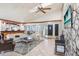 Spacious living room with stone fireplace, wood beams, and tile floors with views into the kitchen at 7321 Caladesia Dr, Sarasota, FL 34243