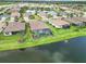 Aerial view of backyard and pool with lake view in community with mature landscaping at 7327 Summerland Cv, Bradenton, FL 34202