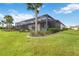 Lush backyard featuring a screened-in patio with pool, manicured lawn, and a tranquil lake view at 7327 Summerland Cv, Bradenton, FL 34202