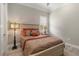 Cozy bedroom featuring neutral tones and accents of orange, with tiled floors and bright lighting at 7327 Summerland Cv, Bradenton, FL 34202