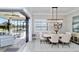 Elegant dining room with sliding glass doors opening to a screened-in lanai and water views at 7327 Summerland Cv, Bradenton, FL 34202